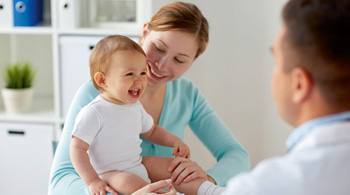 Mom and child wellness check with pediatrician in doctor office.