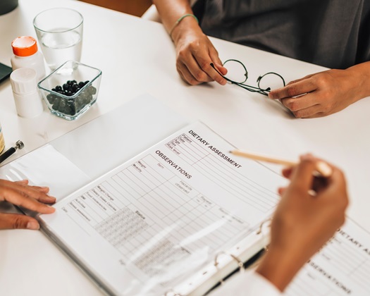 Dietary assessment form. Female nutritionist working with a client