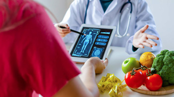 Healthcare professional explaining digital image to patient.